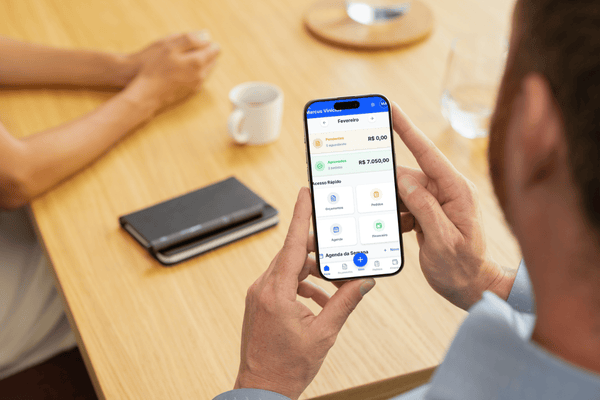 App Orçamento Fácil a ser utilizado no telemóvel sobre mesa de trabalho